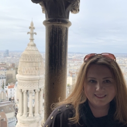 headshot photo of Janelle in front of an overlook of Paris in the background